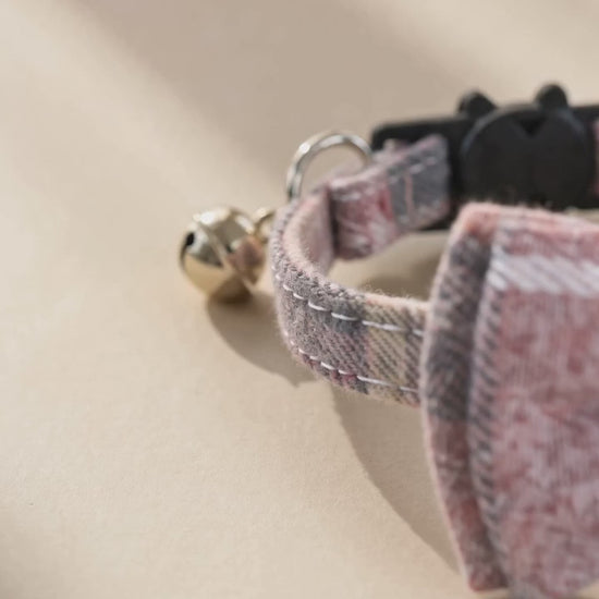 Sakura tweed cat collar with a small bell in warm light.