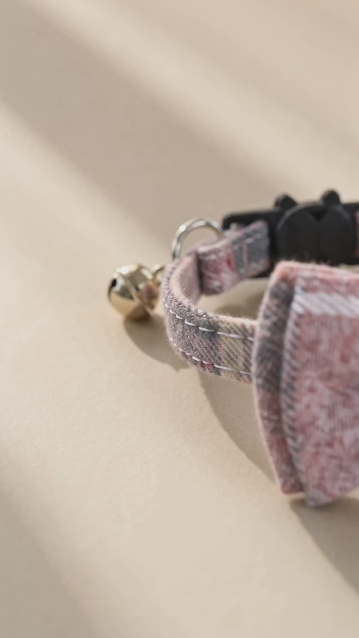 Sakura tweed cat collar with a small bell in warm light.